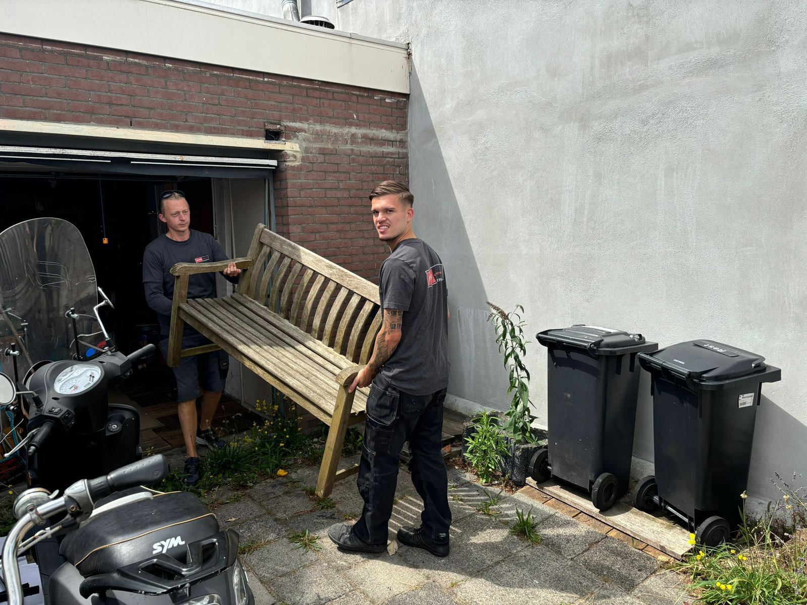 Verhuizers van Rood Verhuizingen dragen meubels naar buiten